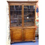 A Regency mahogany bookcase, ebony line inlaid, with two glazed doors on cupboard base with ogee