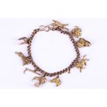 A gold charm bracelet, The 9 carat gold curb-link chain suspending serval charms including a gold