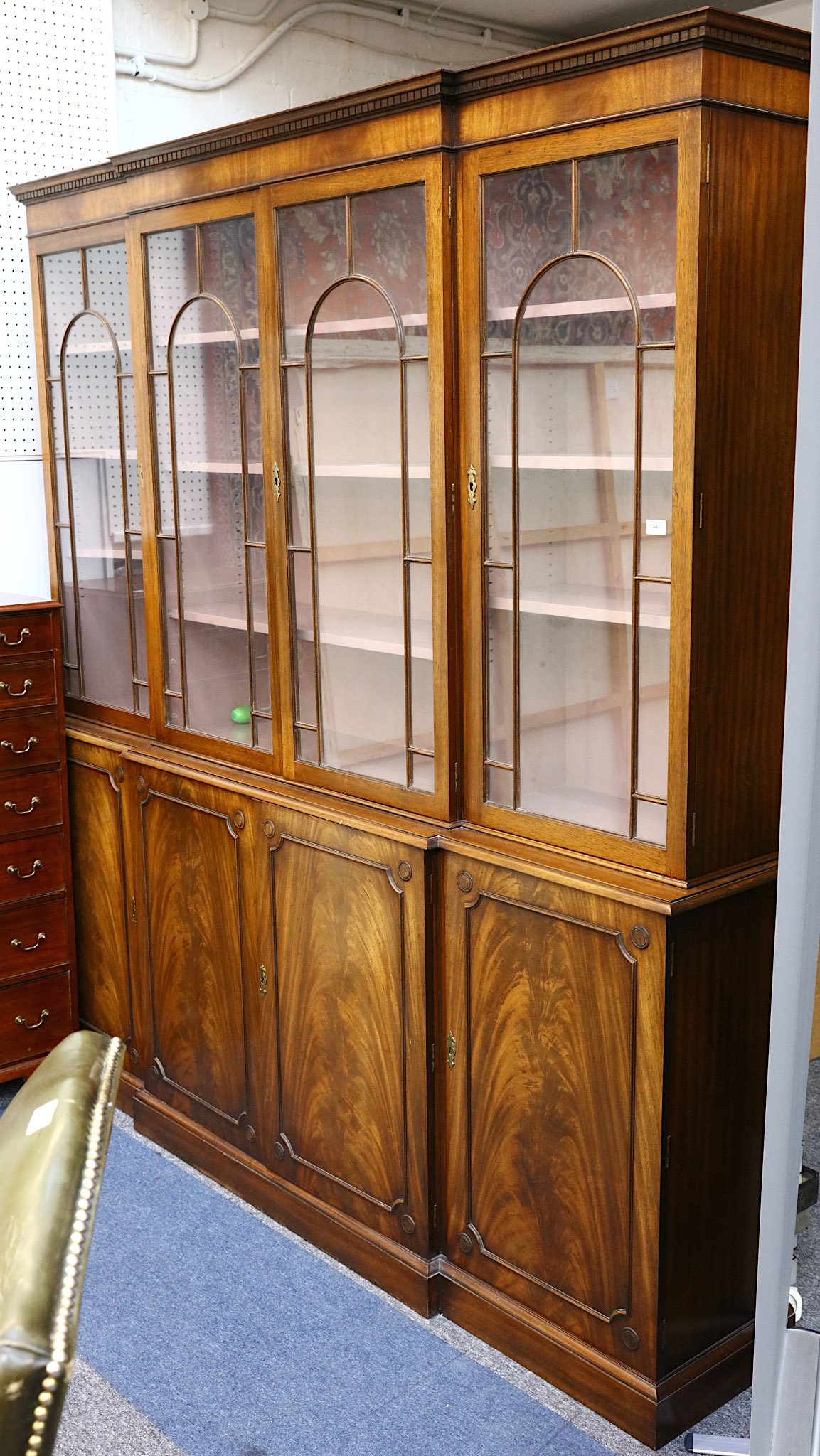 A mahogany breakfront library bookcase in George III style, with dentilled cornice and four doors