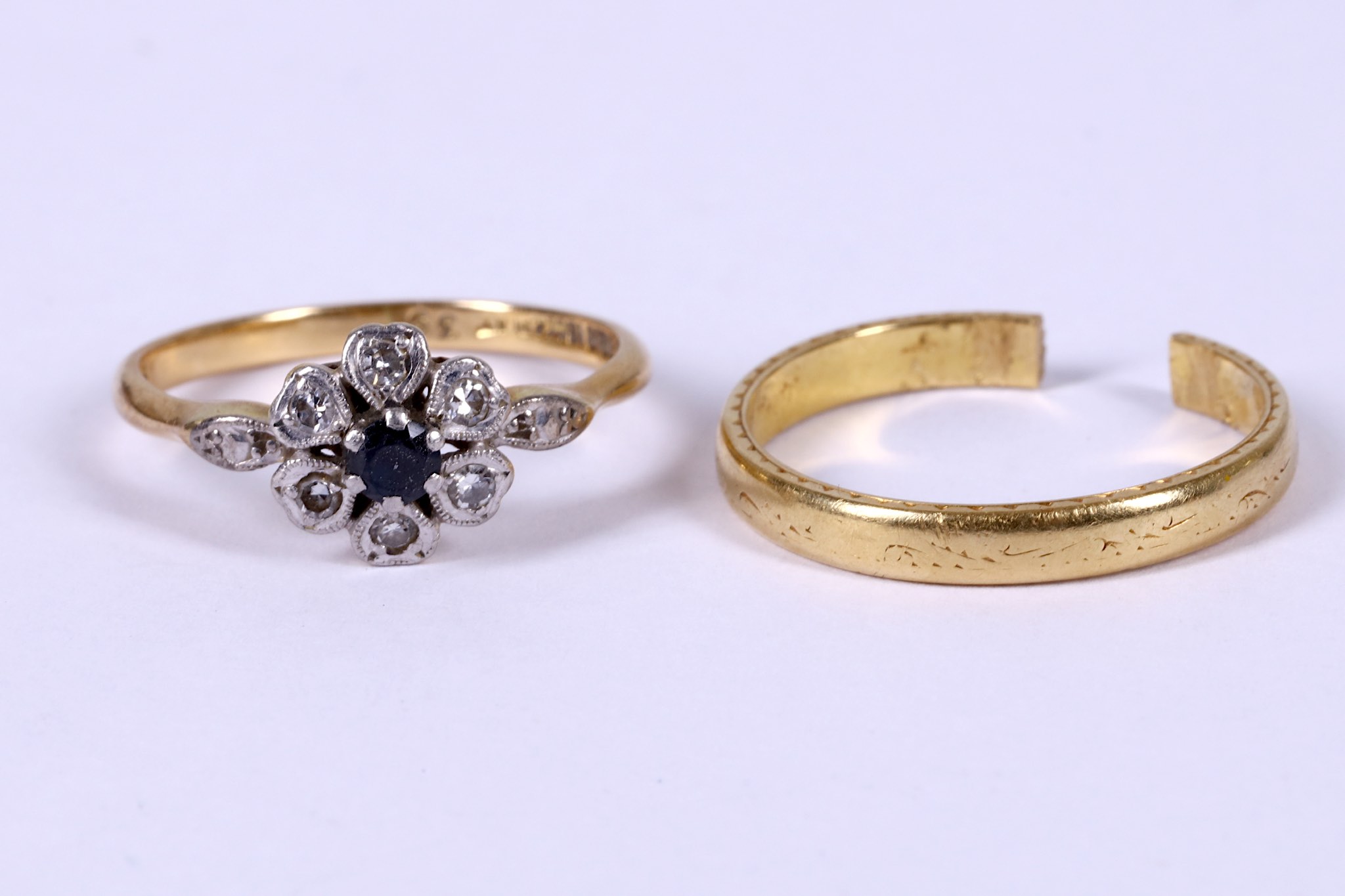 A floral cluster ring set with a sapphire and diamonds and an 18 carat gold band ring (damaged),