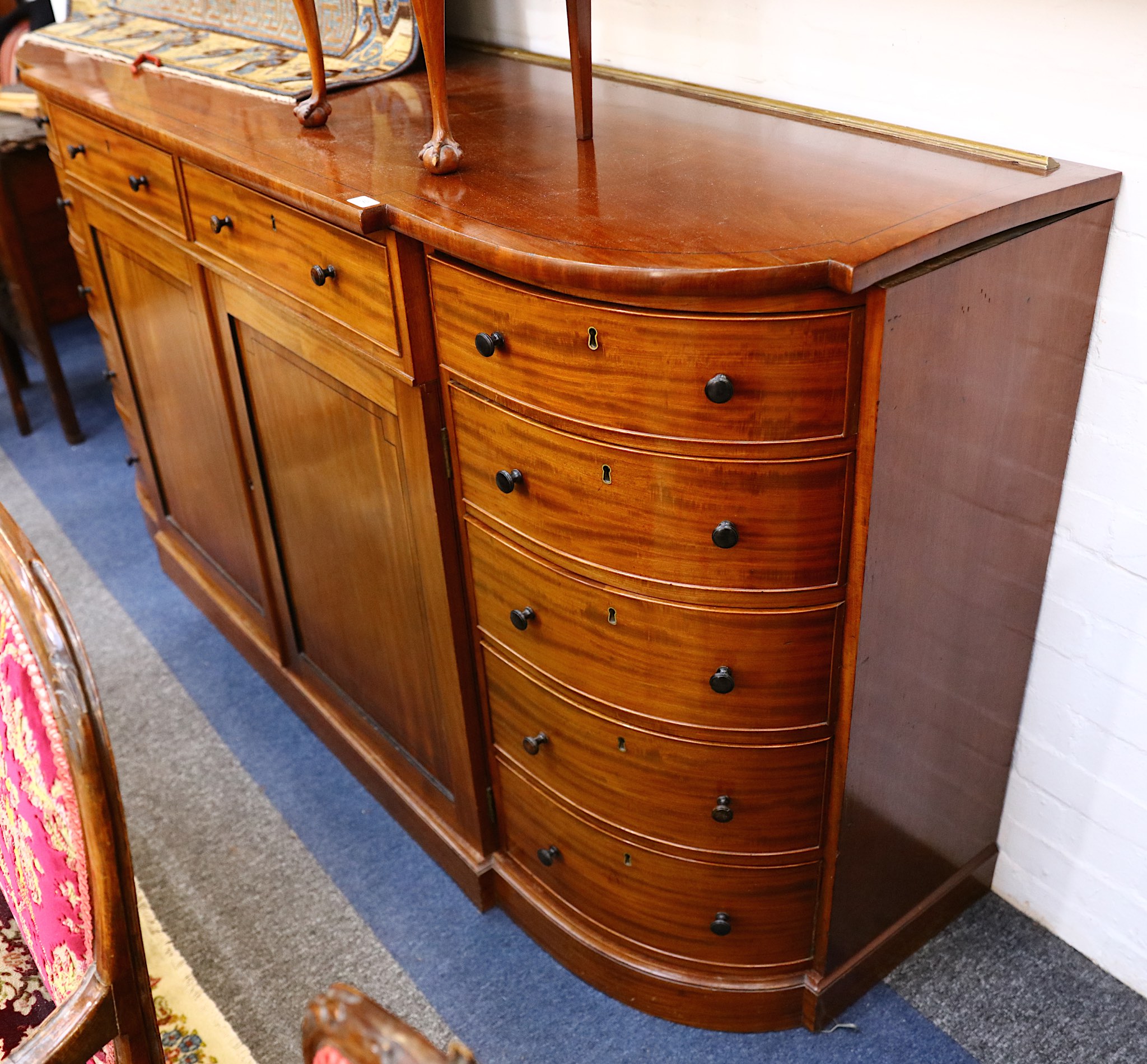 A large Victorian mahogany side cabinet, with bow ends bearing five drawers flanking two drawers and