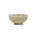 A CHINSE CARVED JADE ‘MUSK-MALLOW’ CUP. Ming Dynasty. The rounded body supported on a flared foot
