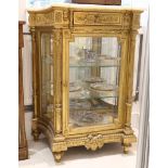 A 19th Century French giltwood and gesso breakfront display cabinet, with associated onyx top over a