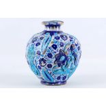 An antique Iznik style earthenware bottle shaped vase, decorated with floral Islamic sprays and
