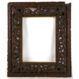 An antique Italian pine frame, carved with cherubs, 76 x 64cm.