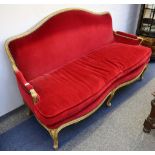 A late 19th Century French, giltwood and gesso settee with fluted frame, upholstered in red