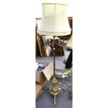 An early 20th Century heavy brass standard lamp of neo-classical design, supported by three