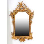 A 19th Century rococo style carved giltwood wall mirror, of arched cartouche shaped design, with