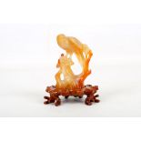 A Chinese carved jade bird of prey on branch, with carved hardwood stands.