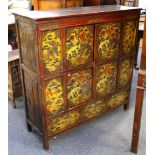 A 20th Century Indian Sino-Tibetan carved wood cabinet, front panels painted with flora and fauna