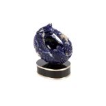 A lapis lazuli carved model of a  pangolin, mounted on a black oval base, with tiger's eye eyes, (