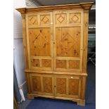 A mid 20th Century, tall pine linen press in two sections over two panelled doors, raised on bracket