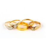 A group of five rings, including three diamond-set rings, a 22 carat gold band and an 18 carat
