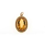 A citrine and half-pearl pendant The oval-cut citrine within a half-pearl surround, length 3.5cm