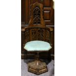 A late Victorian Gothic revival oak swivel chair, with pierced lattice panels on ball column and