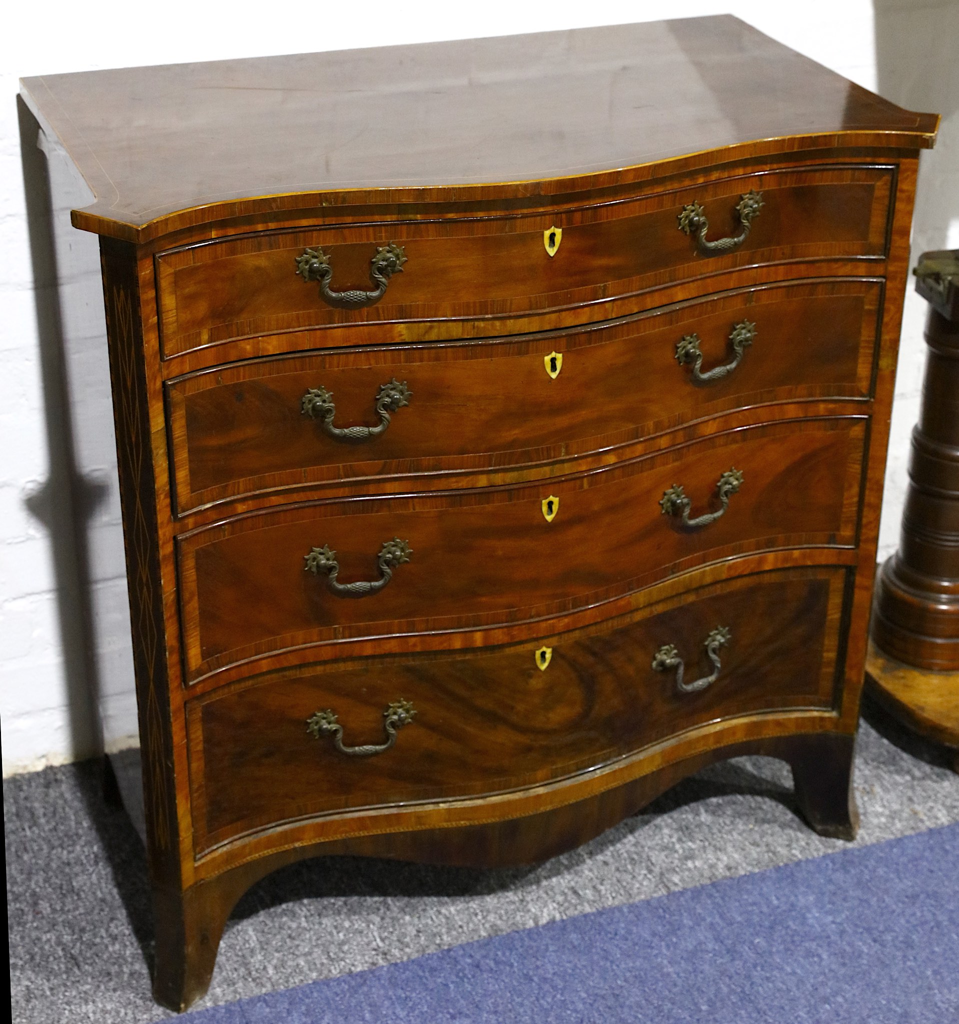 A small George III crossbanded and boxwood strung mahogany serpentine chest, fitted 4 drawers on