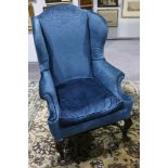 A pair of 19h Century George I style wing armchairs, upholstered in pale blue fabric on angular