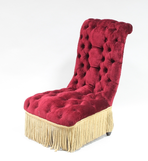 A Victorian button back nursing chair with red velvet upholstery and tasselled fringing and a