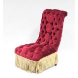 A Victorian button back nursing chair with red velvet upholstery and tasselled fringing and a