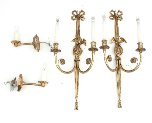 A pair of two-branch brass wall lights with ribbon-tie and eagle mounts,