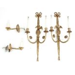 A pair of two-branch brass wall lights with ribbon-tie and eagle mounts,