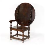 A 17th Century and later oak monk's seat, the pinned top hinged to convert to open armchair,