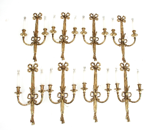 A set of eight Louis XVI style two-branch wall lights with ribbon-tie tassel swags,