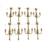 A set of eight Louis XVI style two-branch wall lights with ribbon-tie tassel swags,