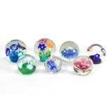 A group of seven floral glass paperweights each with lampwork floral decoration in varying