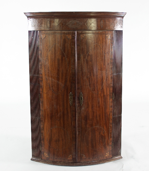A 19th Century mahogany bowfront hanging corner cupboard, inlaid with chequered lines,