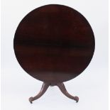 An early 19th Century mahogany table on a turned column and tripod support with carved feet,