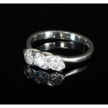A diamond three-stone ring set within a stylised platinum cross-over mount and band,