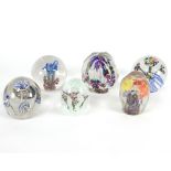 A group of six floral decorated glass paperweights,