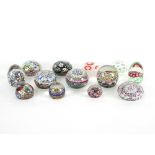 A group of thirteen mainly Murano glass paperweights, each with varying floral cane designs,