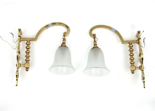 A pair of brass single-light wall lights with glass shades,