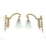 A pair of brass single-light wall lights with glass shades,