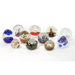 A group of eleven various glass paperweights to include bubble worked and floral decorated examples