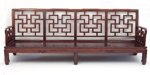 A pair of Chinese hardwood settees, each with four panelled lattice style backs and arms,