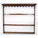 A George III oak and fruitwood delft plate rack of three shelves with shaped frieze,