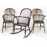 A pair of stick and pierced splat back armchairs with solid seats on turned legs and a stick back