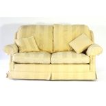 A pale yellow upholstered two-seater settee, with scroll arms and straight back,