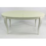 A contemporary dining table of oval form with cabriole legs in a white gloss finish with extending