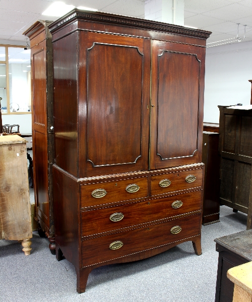 An early 19th Century mahogany linen press, the double panel doors enclosing a hanging rail,