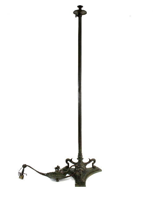 A bronze standard lamp, modelled as an oil lamp on reeded column to a triform base,