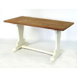 A pine kitchen table with white painted trestle style support,