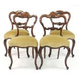 A set of four William IV rosewood framed chairs with scroll carved backs and splats,