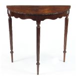 A Mahogany half-round table, with shaped apron on turned and reeded legs,