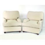 A pair of contemporary Howard style cream upholstered armchairs on turned bun feet/see illustration