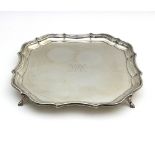 A silver salver, Barker Brothers, Chester 1919, of shaped square form, on four feet,