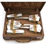 A plated and enamel six-piece dressing table set with floral and butterfly decoration,